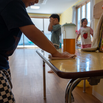 子どもがテーブルの拭き掃除を行う様子