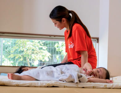 保育士が園児を寝かしつける様子