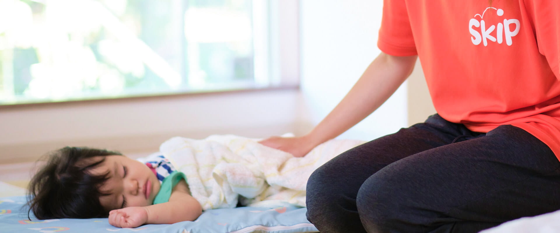 保育士が園児を寝かしつける様子