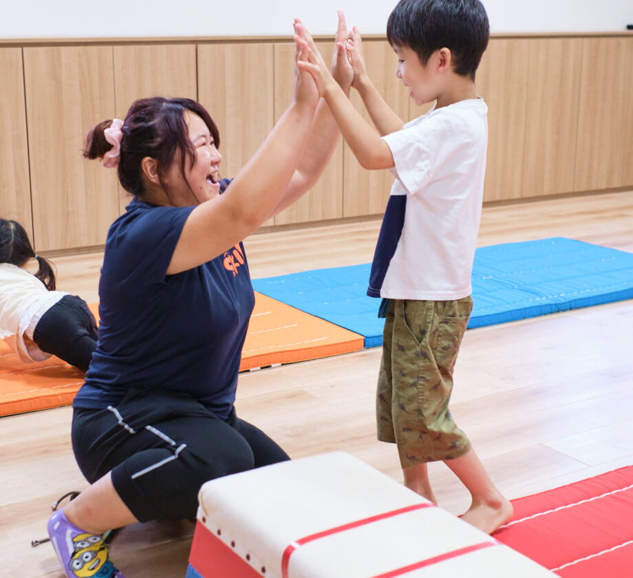 保育士と園児がハイタッチする様子
